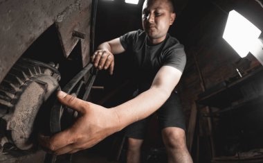 Bir işçi ev atölyesinde çalışmak için bir ahşap işçiliği makinesi hazırlar. Kendi ellerinle metal ürünler yapıyorsun.