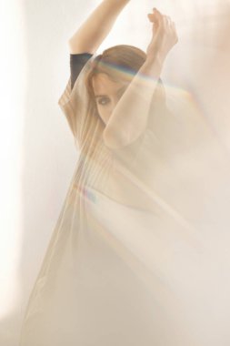 Açık renk giysiler içinde dans eden güzel bir genç kadın. Parlak bir odada şehvetli bir dans. Önemli noktalar. Peçe