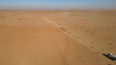 Riyad yakınlarındaki Suudi Arabistan çölünde uluslararası ralli etkinliğini yöneten bir yarış kamyonunun hava görüntüsü.