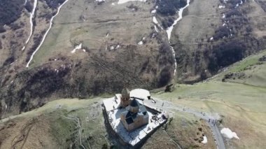 Kamera insansız hava aracı etrafta uçuyor ve Gürcistan 'ın Stepantsminda kasabası yakınlarındaki Kutsal Üçleme Kilisesi' ne (Gergeti Trinity Kilisesi) iniyor.