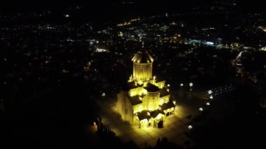 Tiflis 'in Kutsal Üçlü Katedrali' ne gece aydınlatılmış bir kamera İHA iniyor.