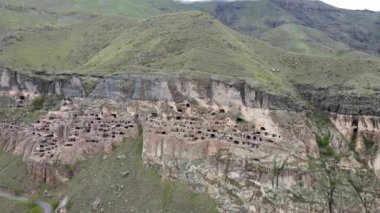 Bir kamera İHA 'sı Vardzia mağara şehri ve manastırına doğru uçuyor.