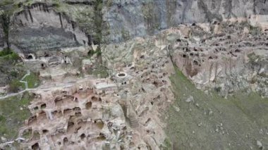 Bir kamera dronu yaklaşıyor ve Vardzia mağara şehri ve manastırı boyunca uçuyor.