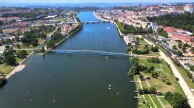 Mondego Nehri, Pedro e Ins (ön planda) ve Coimbra, Portekiz 'deki Santa Clara Köprüsü üzerinde bir kamera dronu ileri uçar.
