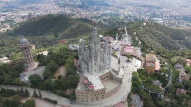 A camera drone flies around the Temple of the Sacred Heart of Jesus and Tower of the Waters of Two Rivers, Barcelona, Spain