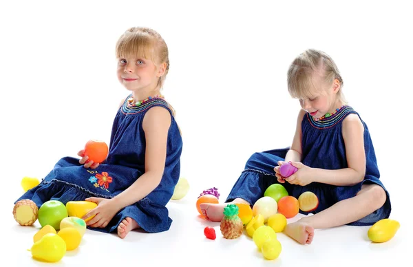 Little girl and fake fruits — Stock Photo, Image