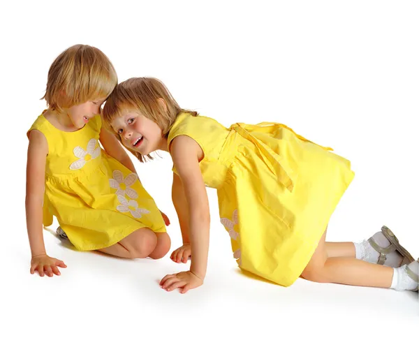 Sisters twins in yellow dresses — Stock Photo, Image