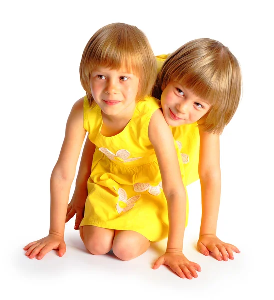 Sisters twins in yellow dresses — Stock Photo, Image