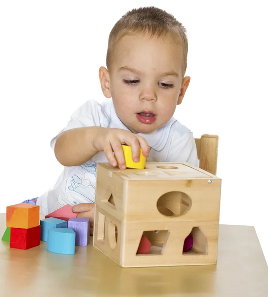 Den lilla pojken spelar vid ett bord — Stockfoto