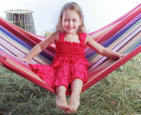 Girl swinging on a hammock in the hay — Stock Photo, Image