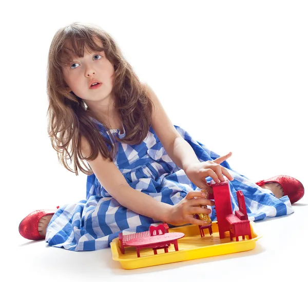 Cute little girl playing in the dollhouse — Stock Photo, Image