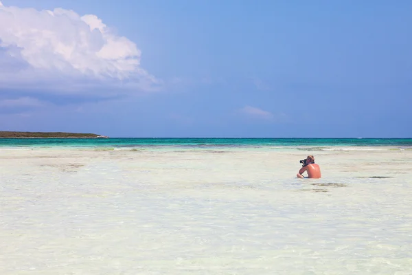 Fotograaf op een paradijs strand — Stockfoto