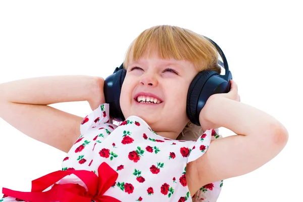 Beautiful little girl in white dress listening to music with hea — Stock Photo, Image