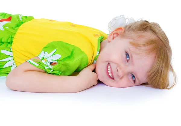 Όμορφο κοριτσάκι σε ένα πράσινο φόρεμα με τις μαργαρίτες, βρίσκεται σε ένα c — Φωτογραφία Αρχείου