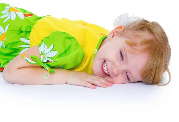 Krásná holčička v zelených šatech s sedmikrásky, spočívá v c — Stock fotografie