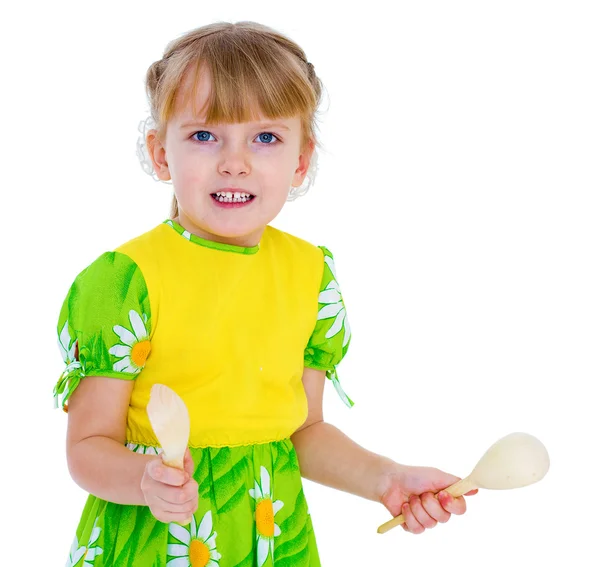 Klein meisje spelen op houten lepels. — Stockfoto