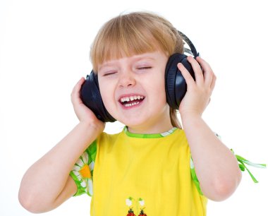 Charming little girl loves to listen to music through headphones clipart