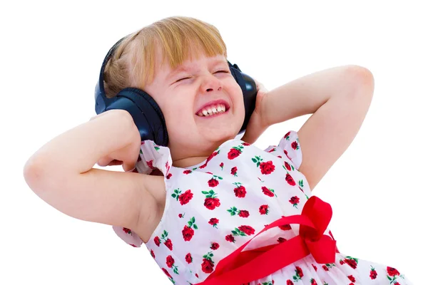 Charming little girl loves to listen to music through headphones — Stock Photo, Image