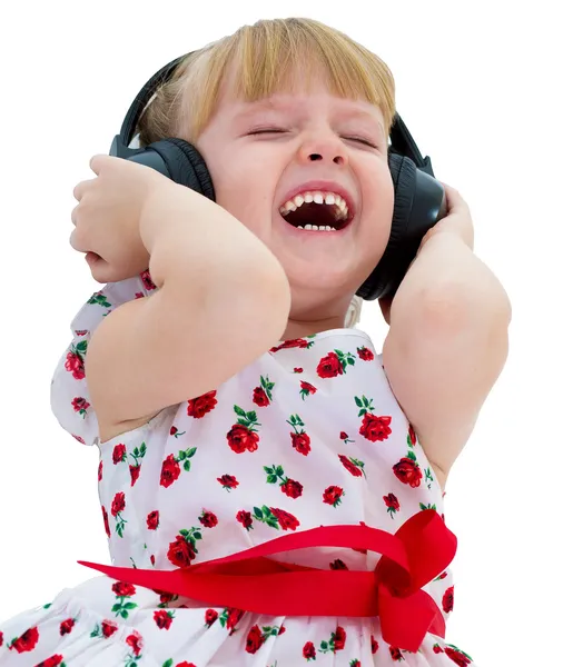 Charming little girl loves to listen to music through headphones — Stock Photo, Image