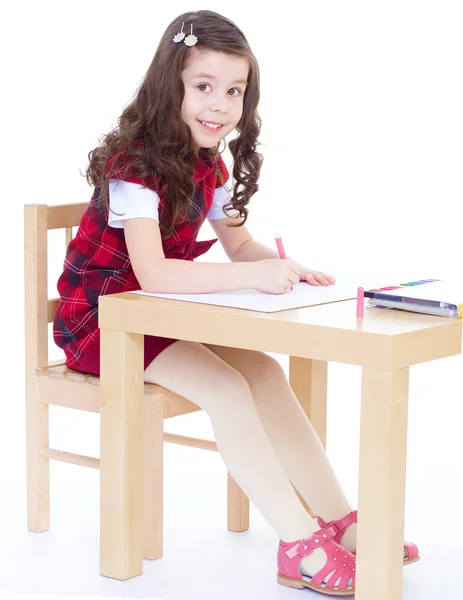 Little girl is drawing using color pencils while sitting at tabl — Stock Photo, Image