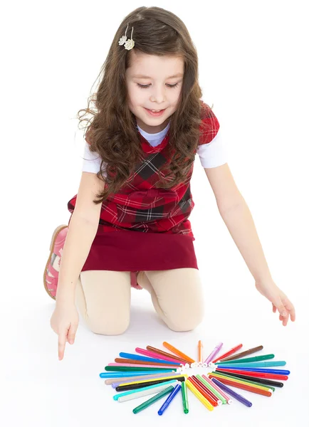 Kleines Mädchen, das auf dem Boden sitzt und mit bunten Stiften spielt. — Stockfoto