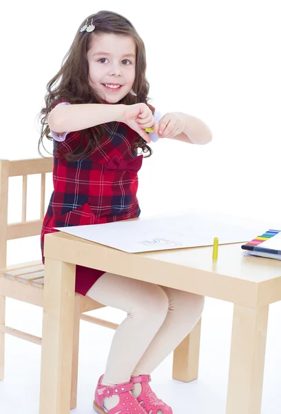 Niña está dibujando usando lápices de color mientras está sentada en tabl — Foto de Stock