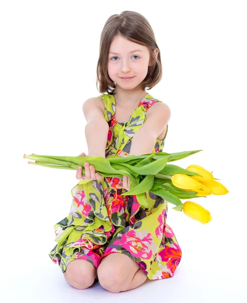 Meisje met gele tulpen. — Stockfoto
