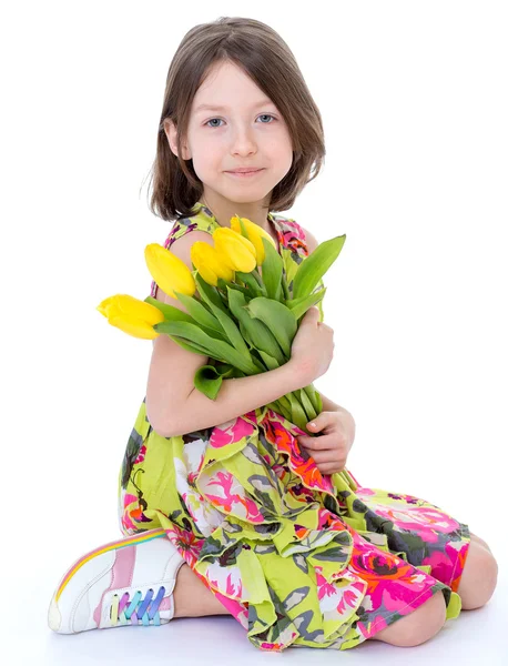 Kleines Mädchen mit gelben Tulpen. — Stockfoto