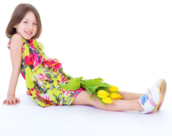 Little girl with yellow tulips. — Stock Photo, Image