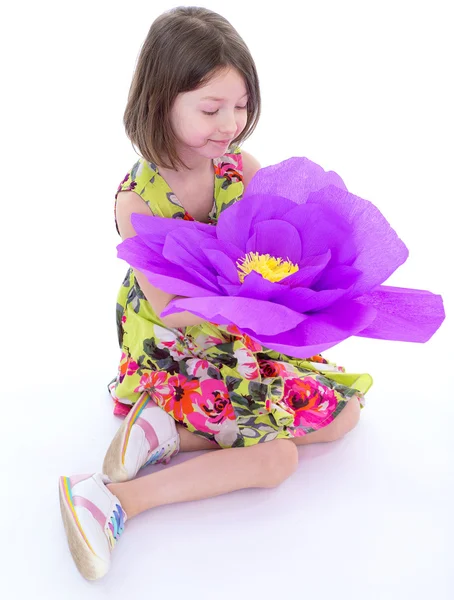 Charmant klein meisje met een reusachtige bloem. — Stockfoto