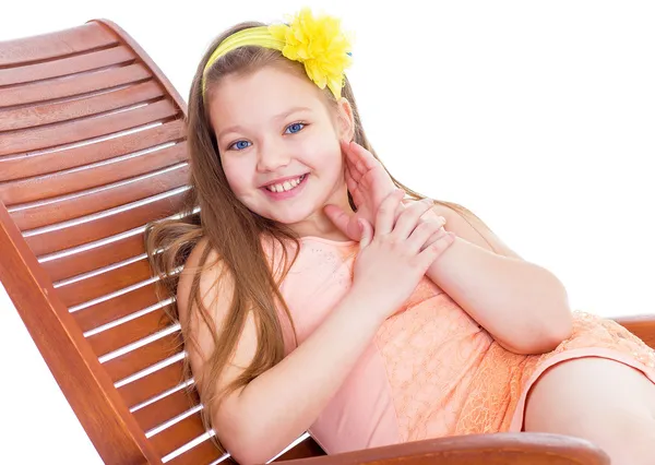 Young girl on a lounger with a glass of juice. — Stock Photo, Image