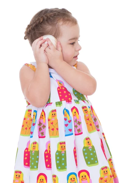 Little girl listening to seashell — Stock Photo, Image