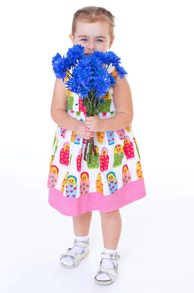Liten flicka med blå blommor — Stockfoto