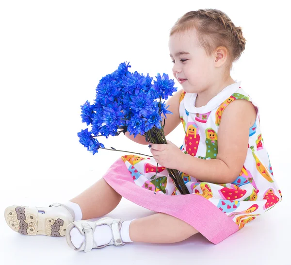 Liten flicka med blå blommor — Stockfoto