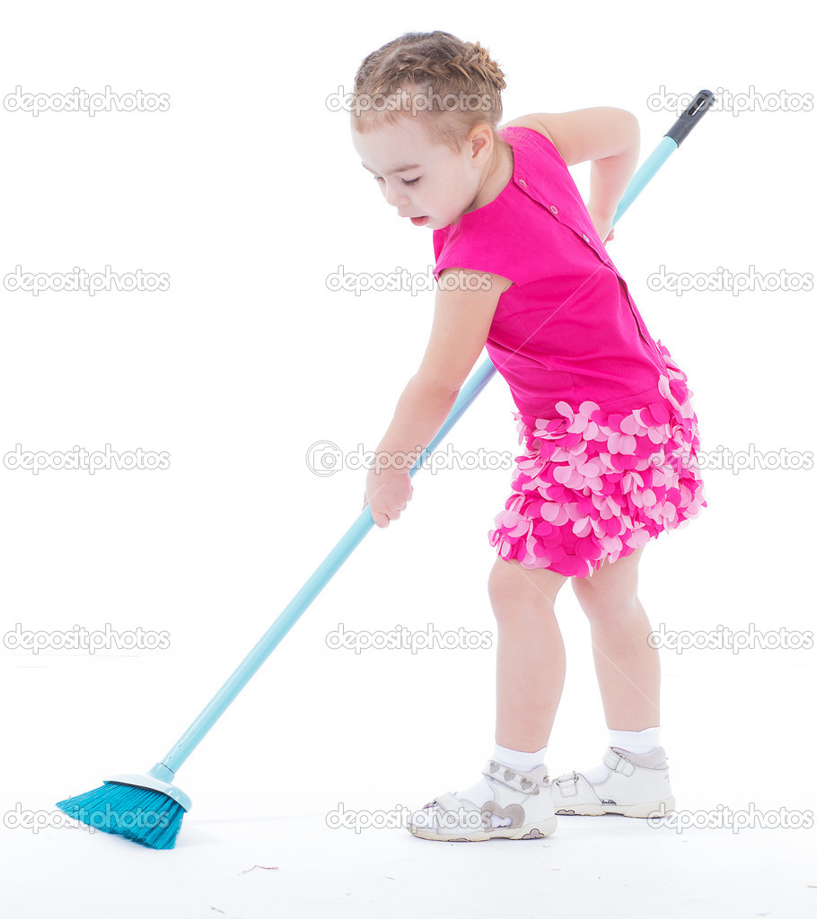 Cute little girl sweeps a floor isolated on white