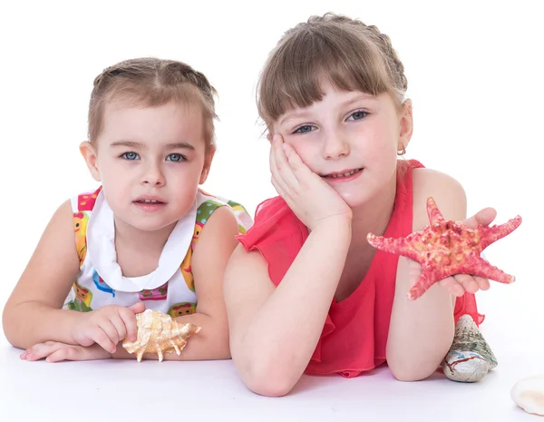 Kabukları ve denizyıldızı oynayan iki küçük kız.. — Stok fotoğraf