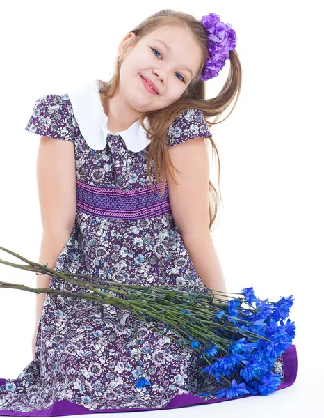 Charmant klein meisje met een boeket van bloemen. — Stockfoto