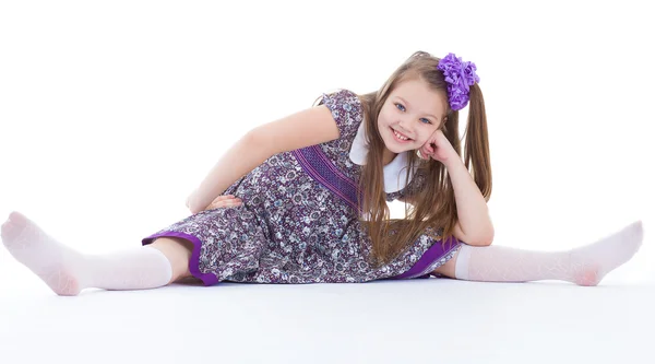 A beautiful young girl sits on a twine. — Stock Photo, Image