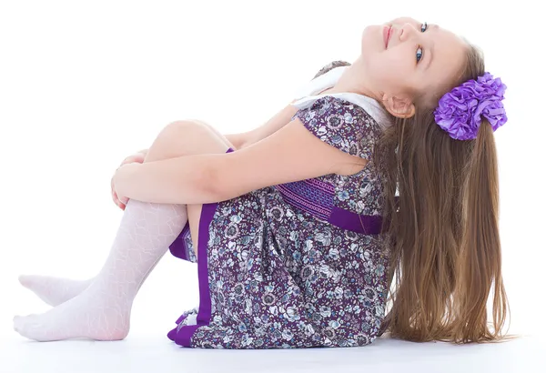 Charmant klein meisje, zittend op de vloer. — Stockfoto