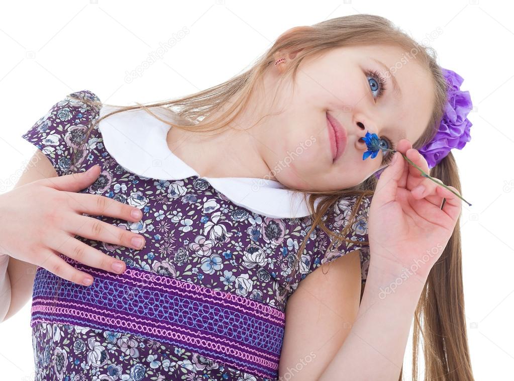 Little girl enjoys the smell of flowers