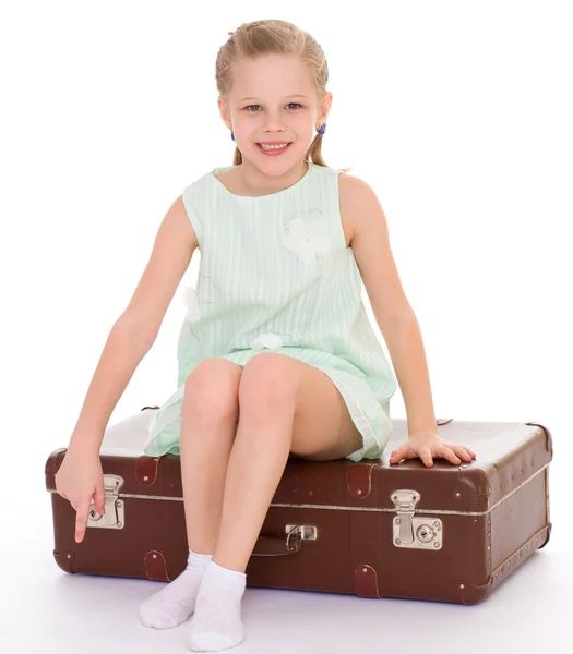 Little girl with a big and very old suitcase. — Stock Photo, Image