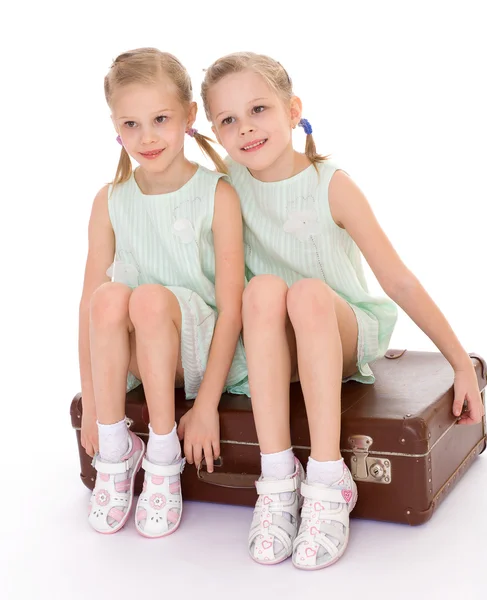 Hermanas gemelas con una gran maleta vieja . —  Fotos de Stock