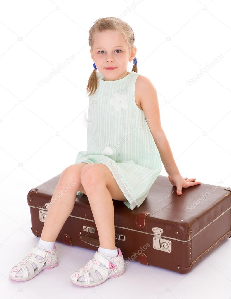  little girl with a big and very old suitcase.