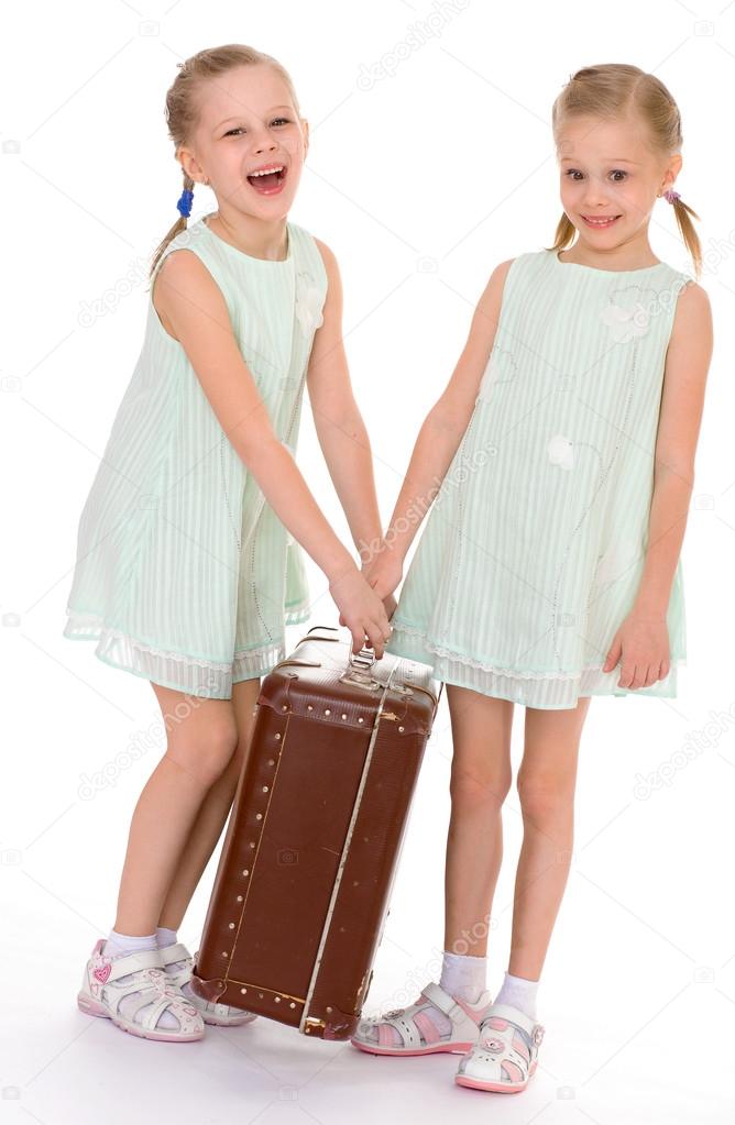  twin sisters with a big old suitcase.