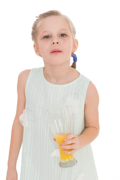Cute little girl drinks orange juice — Stock Photo, Image