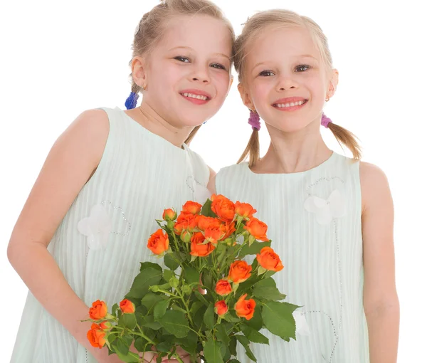 Twee charmante meisjes met boeketten van rozen. — Stockfoto