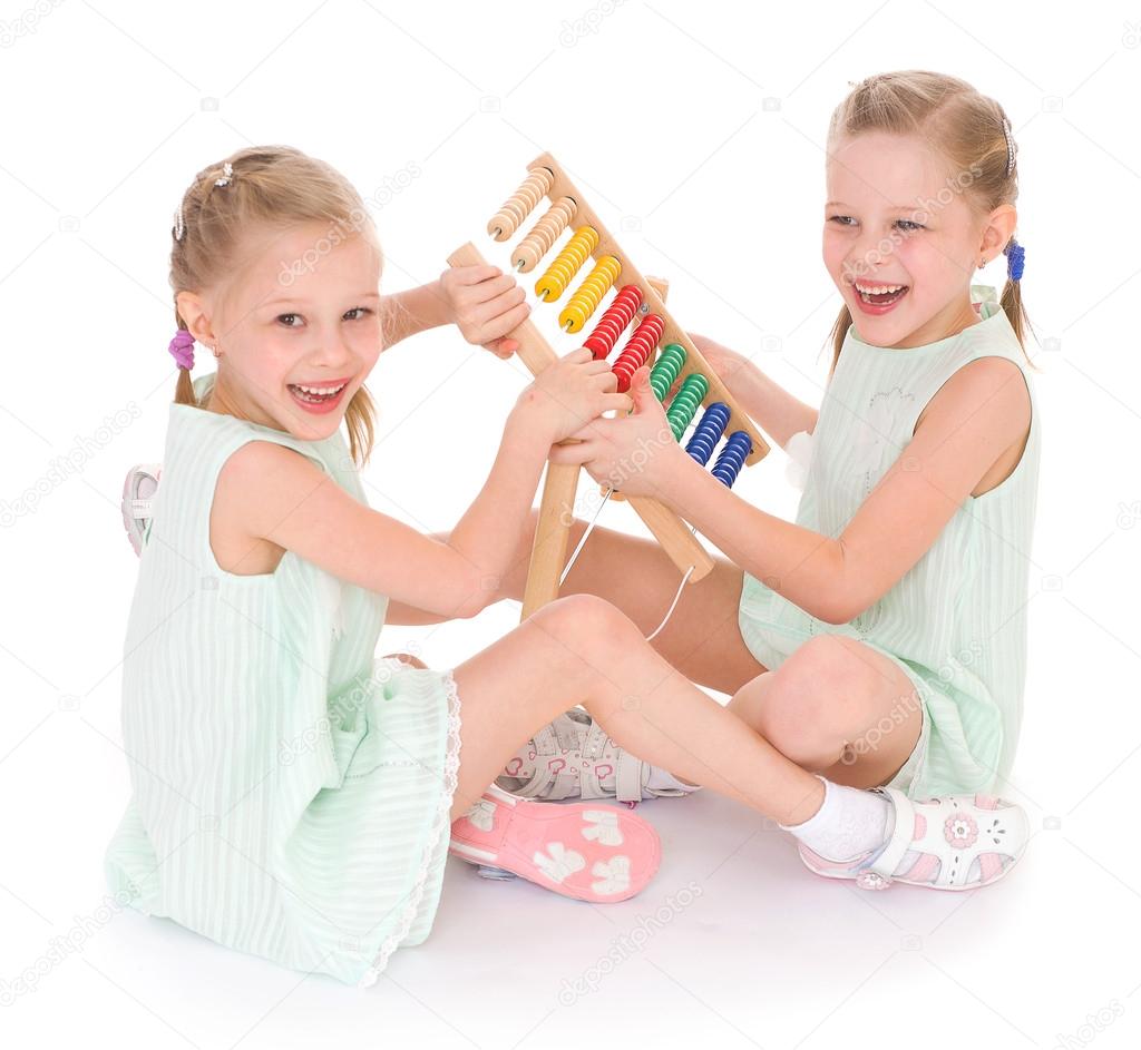 Cute sisters work in the Montessori environment.