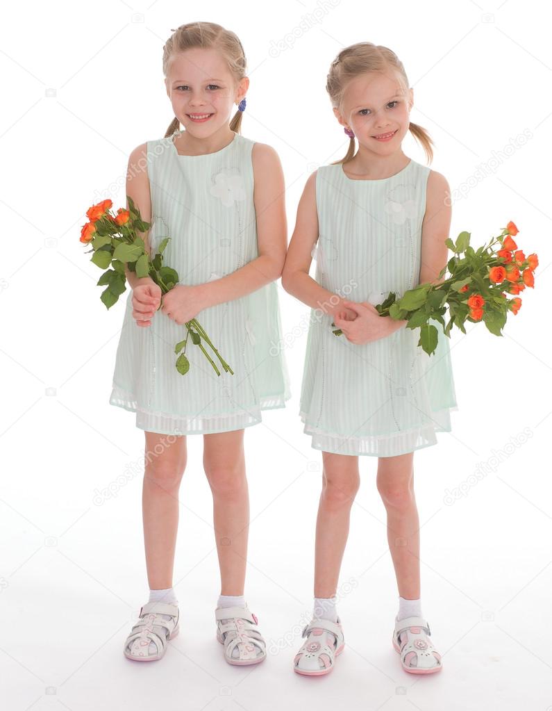 Two charming girls with bouquets of roses.