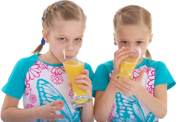 Irmãs gêmeas gostam de beber suco de laranja . — Fotografia de Stock