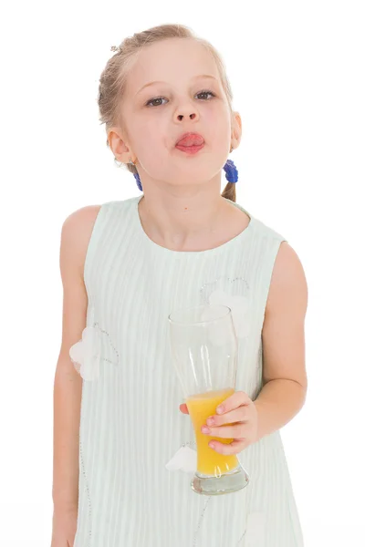 Cute little girl drinks orange juice — Stock Photo, Image